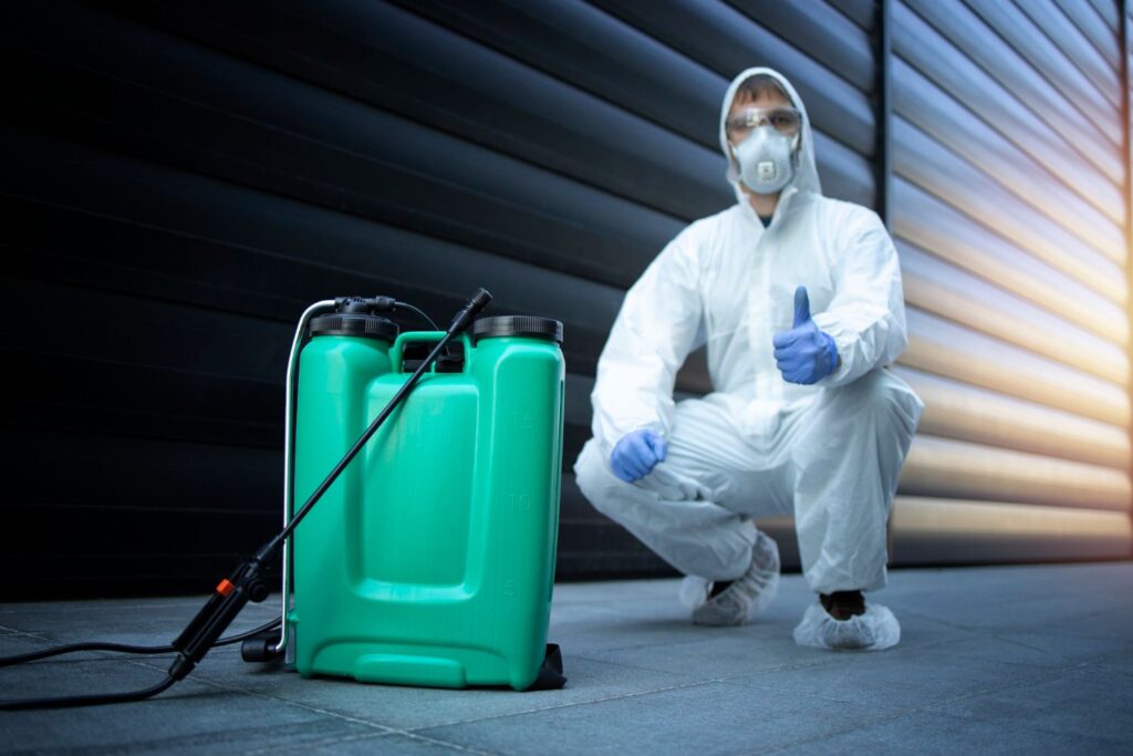 exterminator with a green spraying machine